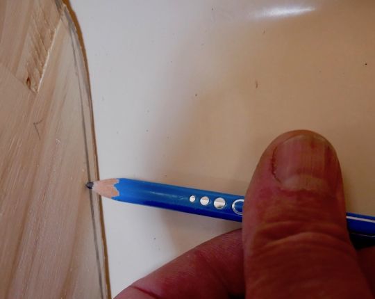 Un crayon tenu à plat pour un ajustage fin