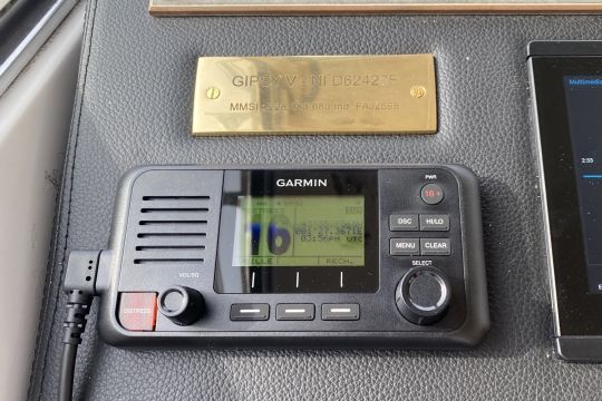 La VHF fixe avec un plaque stipulant l'immatriculation du bateau et l'indicatif radio