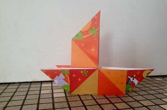 Un petit voilier en origami avec une voile droite