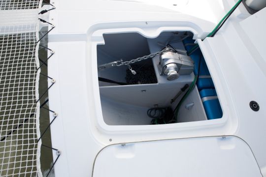 Un guindeau horizontal dans la baille à mouillage d'un catamaran