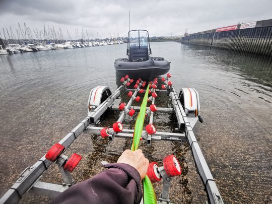 Tenir la sangle tendue permet de maintenir le bateau calé entre les rouleaux et ainsi éviter qu'il ne se déporte.