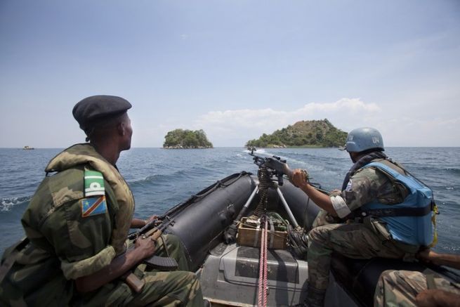 Un casque bleu de la MONUSCO et un soldat de lArme nationale congolaise (FARDC) sont en patrouille sur le Lac Tanganyika 
